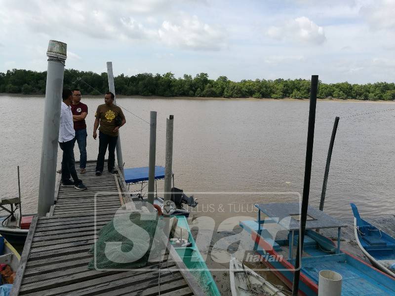 Arzzuri (kanan) bersama penduduk meninjau keadaan jeti di Bagan Sungai Yu.
