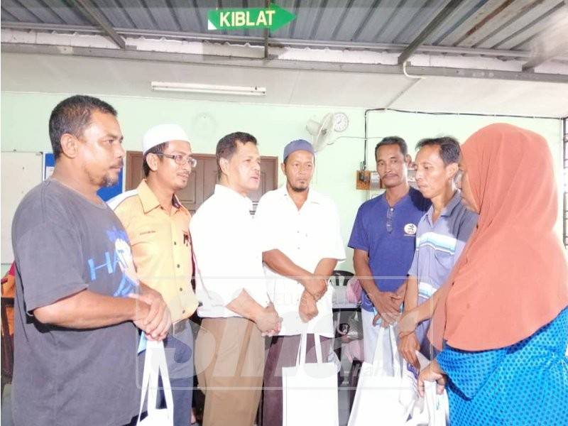 Zahar (tiga, kiri) bersama Pengerusi Majlis Pengurusan Komuniti Kampung (MPKK) RPT Kampung Sri Aman, Azha Md Isa (dua, kiri) ketika bertemu waris lima mangsa kebakaran rumah kedai, hari ini.
