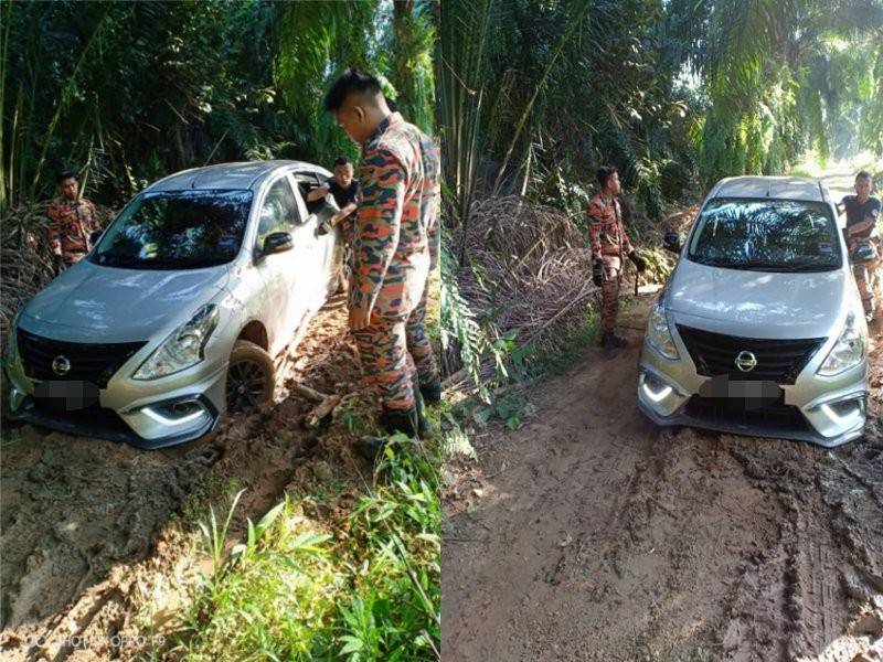 Anggota bomba membantu menolak kenderaan milik mangsa yang sesat dalam ladang kelapa sawit semalam.