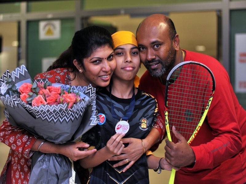 S. Moganasundharam (kanan) bersama isteri Shanthimary Palvinder Kaur (kiri) memeluk anak mereka Nickhileswar yang muncul juara kategori lelaki bawah 11 tahun pada Kejohanan Skuasy Terbuka Remaja (BJO) 2019 di Birmingham, England baru-baru ini sebaik tiba di Lapangan Terbang Antarabangsa Pulau Pinang malam tadi. - Foto Bernama