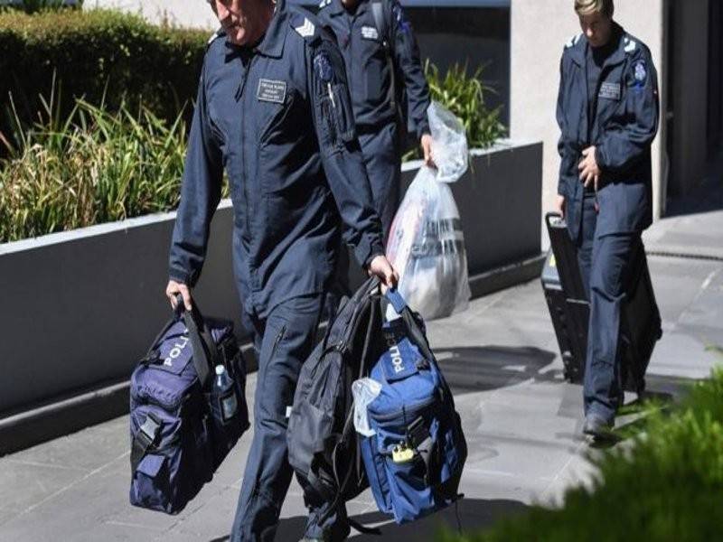 Polis membawa keluar bahan bukti dari bangunan konsulat Itali di Melbourne. - Foto AFP