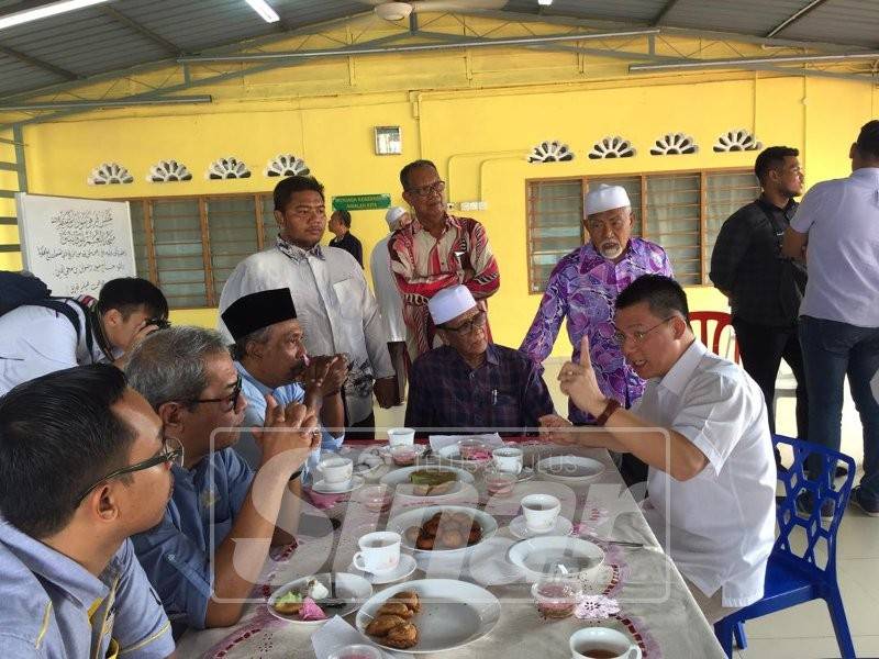 Kor Ming (duduk, kanan) berbincang dengan jawatankuasa Masjid An-Naim, semasa lawatannya, di sini hari ini.