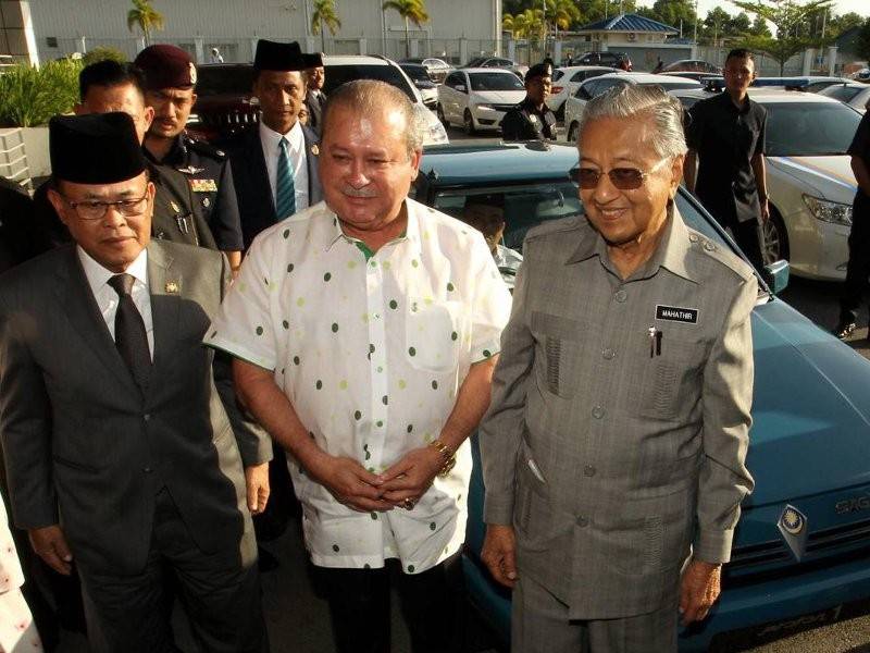 Sultan Ibrahim bersama (tengah) Dr Mahathir dan Menteri Besar, Datuk Osman Sapian di hadapan kereta Proton Saga yang dipandu baginda ke Senai.