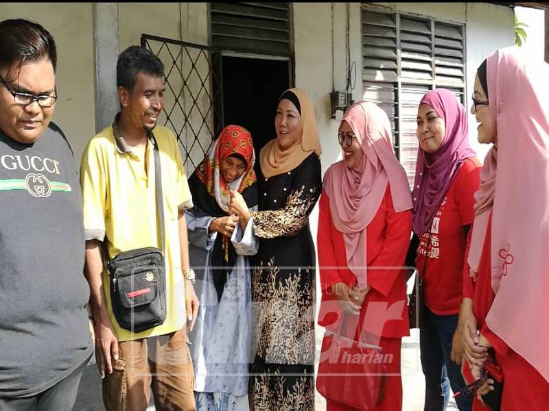 Puteri Holijah (empat, kiri) bersama Nor Izatul Fatiha dan Meor Abdullah (dua, kiri) di hadapan rumah mereka di Kampung Pasir Puteh, petang tadi.