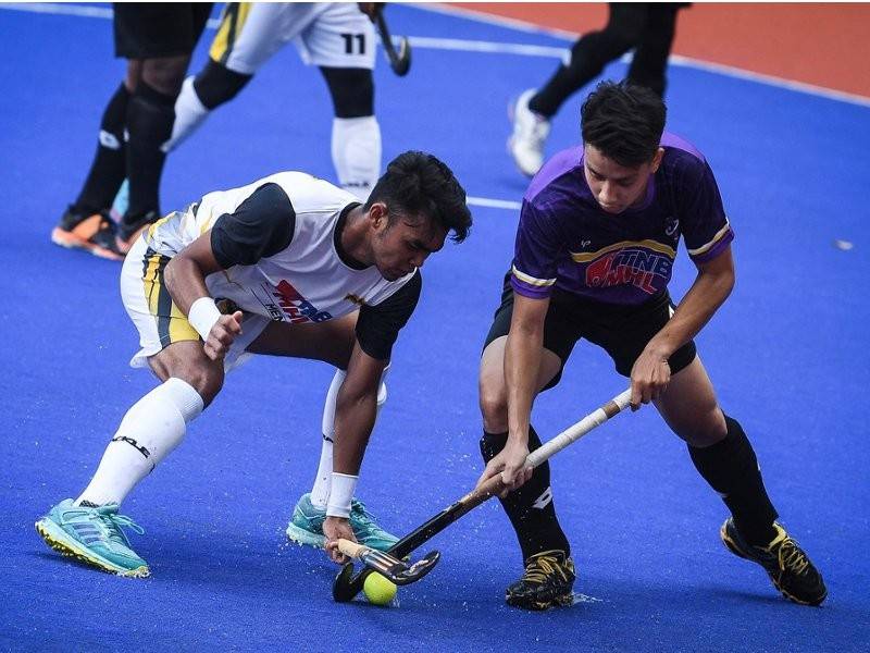 Pemain Maybank Adam Aiman Mamat (kiri) mengasak pemain UiTM Fallah Hassan Shahrom Jamil dalam perlawanan kalah mati Piala Tan Sri P. Alagendra 2019 di Stadium Hoki Nasional Bukit Jalil pada awal Januari. - Foto Bernama