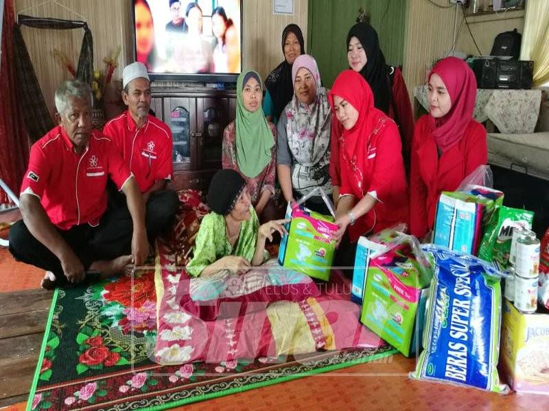 Hidatul Syuhada (dua, kanan) menyerahkan sumbangan lampin pakai buang dan juga keperluan harian kepada Som ketika mengunjungi rumah sewanya di Kampung Tok Adis, Kuala Ibai, di sini. Hadir sama, Ketua Cawangan Bersatu Kuala Ibai, Abdul Wahab Awang (dua kiri).