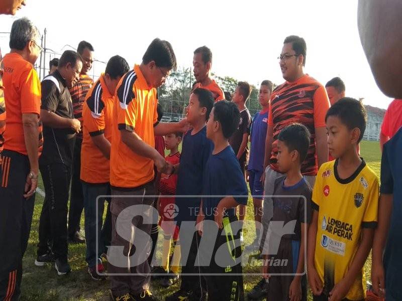 Asmuni beramah mesra dengan pelatih Akademi Bola Sepak Dun Manjoi ketika pelancarannya.
