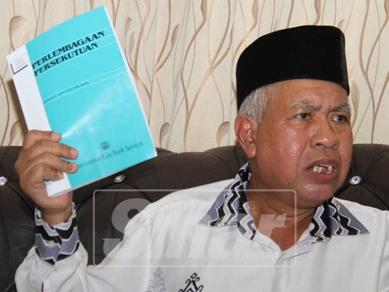 Sallehuddin bersama buku Perlembagaan yang turut menjadi asas dan intipati perjuangannya dalam PRK tersebut.
