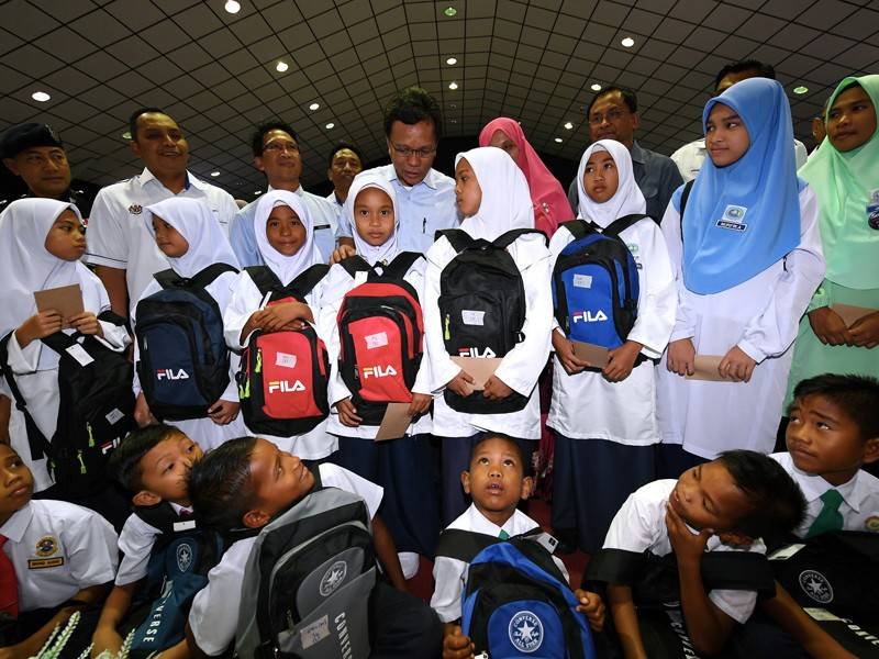 Ketua Menteri Datuk Seri Mohd Shafie Apdal (tengah) beramah mesra dengan sebahagian murid-murid selepas menyampaikan bantuan persekolahan pada majlis Kembali Ke Sekolah di Dewan Masyarakat Semporna hari ini. - Foto Bernama