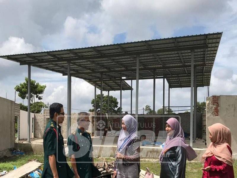 Wan Mohd Salleh (dua, kiri) memberi penerangan mengenai projek pembinaan surau SMK Bukit Kuang kepada Nor Ashikin (tengah).
