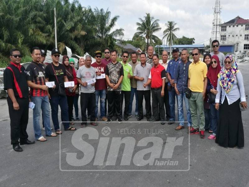 Peniaga Downtown Parit Raja sewaktu menerima wang sumbangan Ahli Parlimen Sri Gading, Dr Shahruddin Md Salleh.
