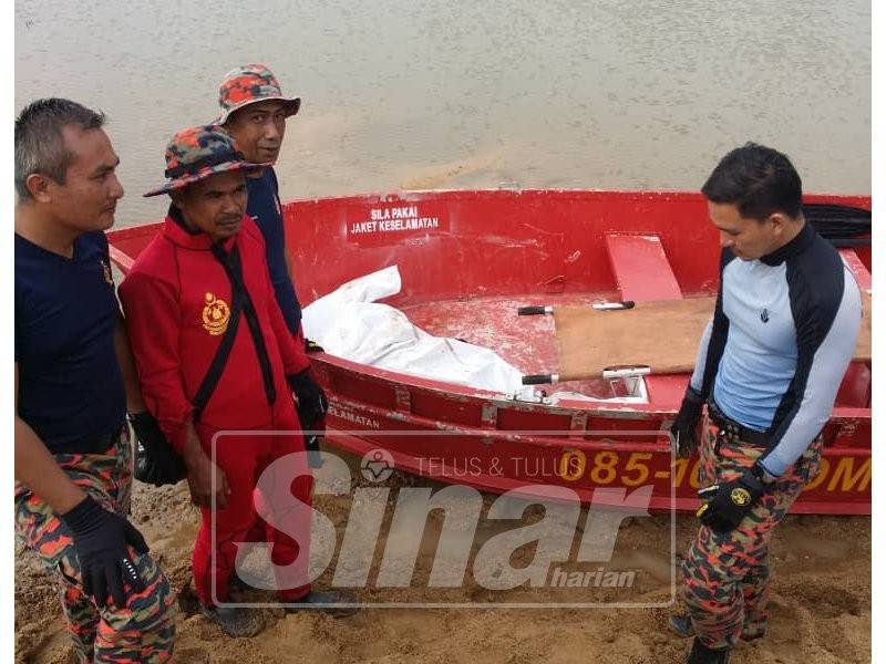 Anggota bomba menaikkan mayat mangsa dan diserahkan kepada polis di tebing Sungai Besut dekat Kampung Tok Raja di seberang kampung Dengir pagi ini.
