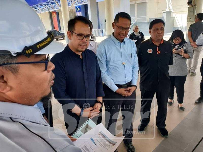 Chee Keong (dua, kiri) dan Mohd Asmirul (tiga, kiri) mendengar taklimat berkaitan pembinaan pusat latihan skuasy.