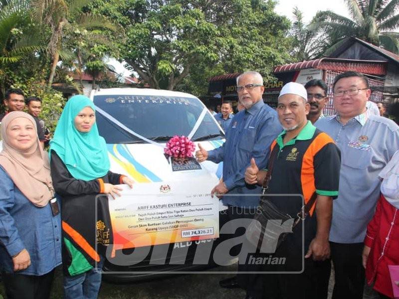 Mahfuz menyerahkan van kepada Noorazizah bagi geran SBGPOKU sempena Karnival Pekerjaan, Kemahiran dan Keusahawanan Insan Istimewa di Kampung Batu 6, Jalan Tanjung Tualang, hari ini.
