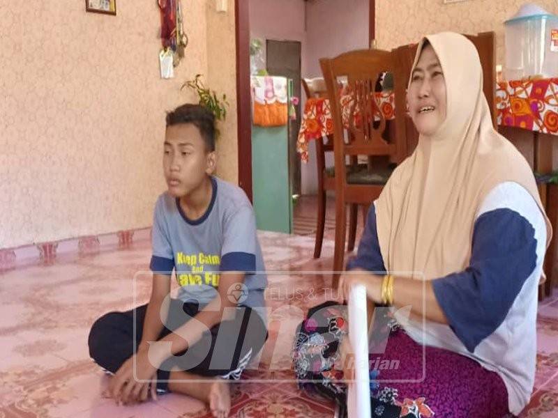 Rohaya bersama anaknya di kediaman mereka di Kampung Pulau Nyior, Yan.
