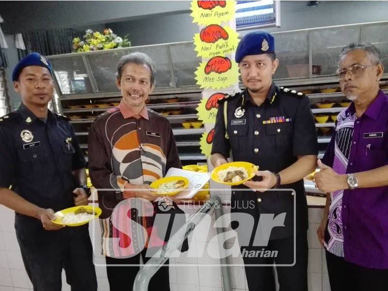 Zulfamy (dua, dari kanan) menunjukkan makanan yang dijual di kantin itu.
