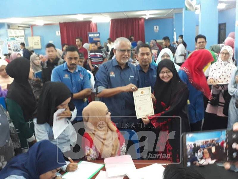 Mahfuz (tengah) menyampaikan sijil penghargaan kepada setiap majikan yang menyertai Program Kerjaya Dun Suka Menanti di Dewan Kelab Kilat TNB, Mergong, hari ini. Turut kelihatan Zamri (empat, kanan).