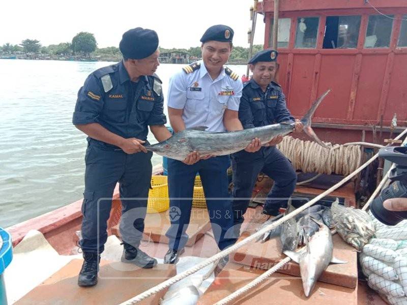 Rashidilhadi (tengah) menunjukkan antara spesies ikan yang dirampas dari bot nelayan Vietnam.
