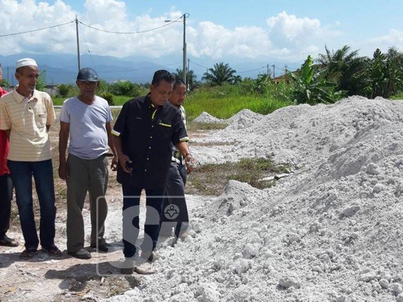 Md Zaki (kanan) bersama penduduk kampung menunjukkan longgokan sisa bahan kimia yang dibuang oleh pihak industri berhampiran dengan rumah penduduk.