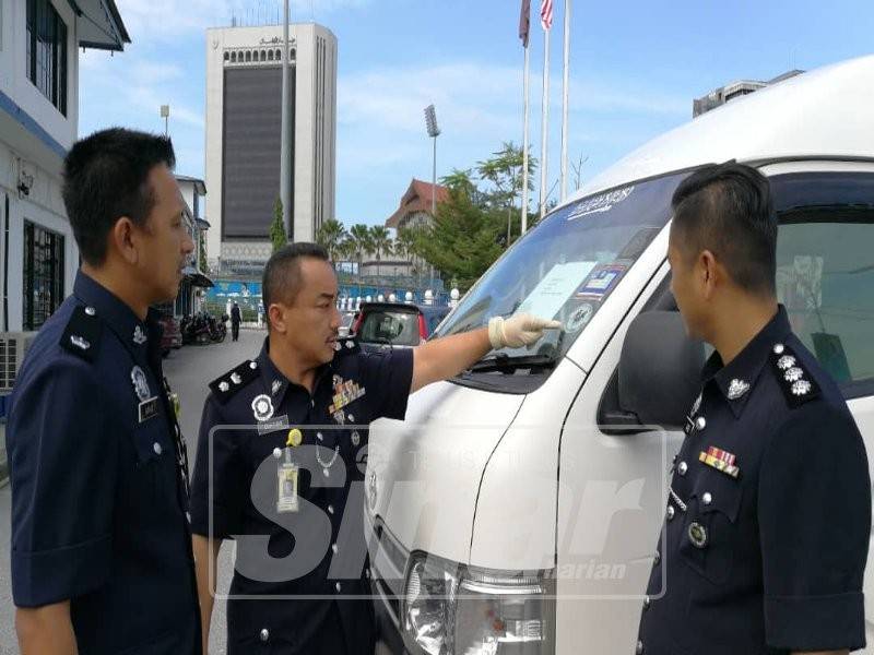 Suffian (tengah) menunjukkan van putih yang turut dirampas.