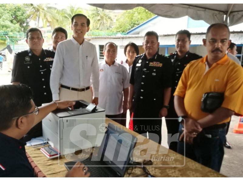 Mohd Abduh (tiga, kanan) melihat orang awam yang membuat semakan saman di IPD Kluang.