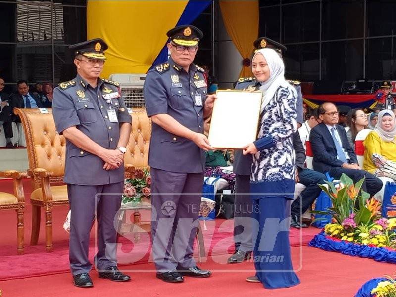 Nur Ain Fitri (kanan) ketika menerima sijil penghargaan khas dari JBPM di Putrajaya yang disampaikan oleh Ketua Pengarah JBPM, Datuk Mohamad Hamdan Wahid.
