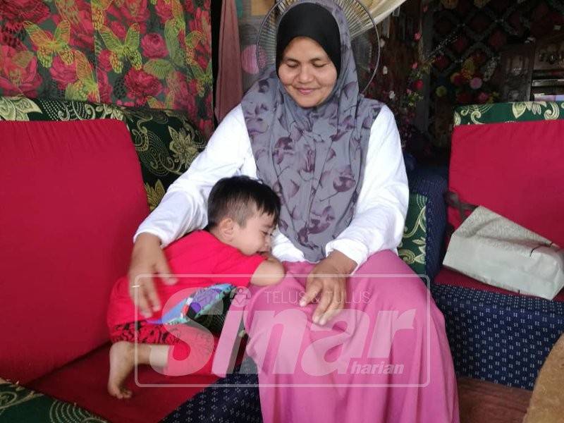 Rahimah melayan anak bongsunya, Mikail ketika ditemui tadi.
