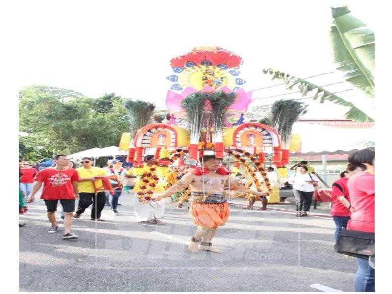 Andrew Chong diiringi ahli keluarganya membawa kavadi simbolik membayar nazar pada sambutan Thaipusam di kuil Gunung Cheroh, hari ini.