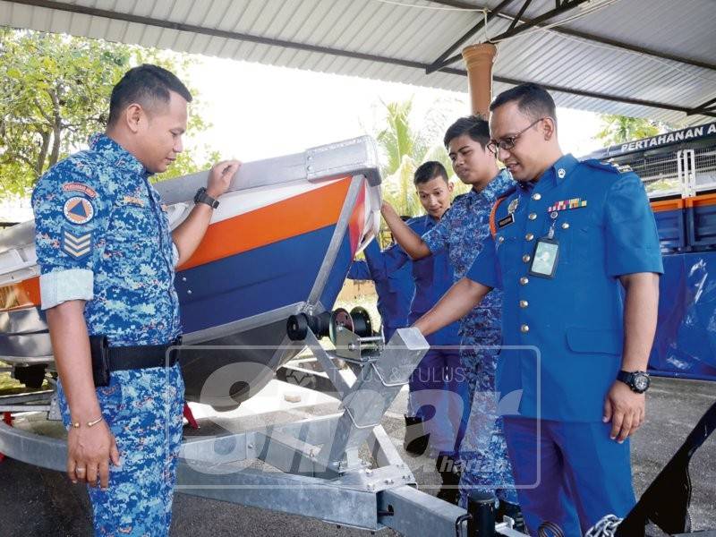 Fazlisyah (kanan) memeriksa bot yang juga aset milik APM bagi kerja-kerja menyelamat.