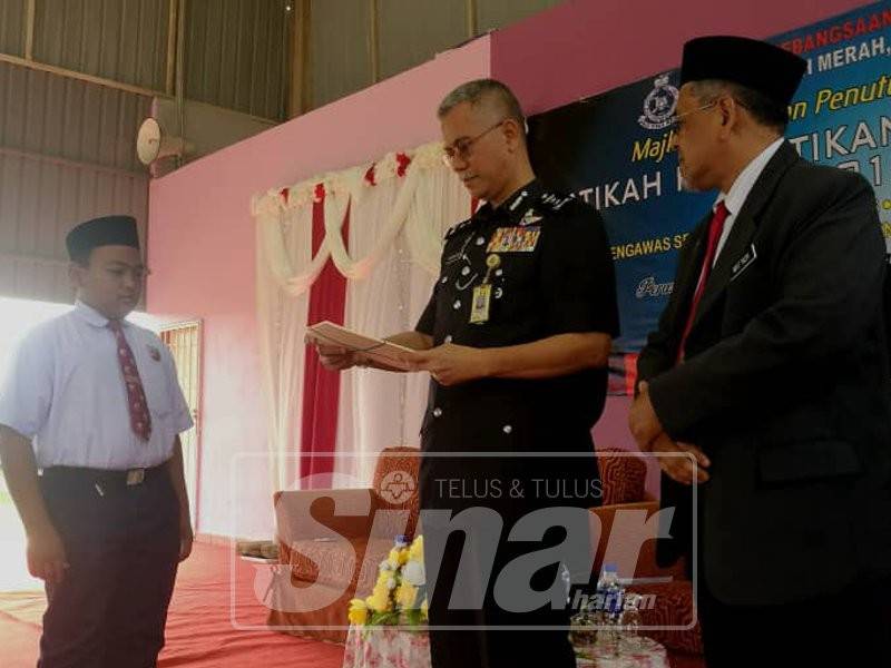 Hasanuddin (tengah) menyampaikan watikah pelantikan Pemimpin Kecil di SK Suria 1 di sini hari ini.