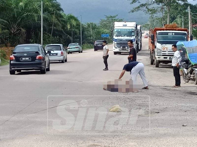 Oramg ramai menutup mayat mangsa dengan kain.