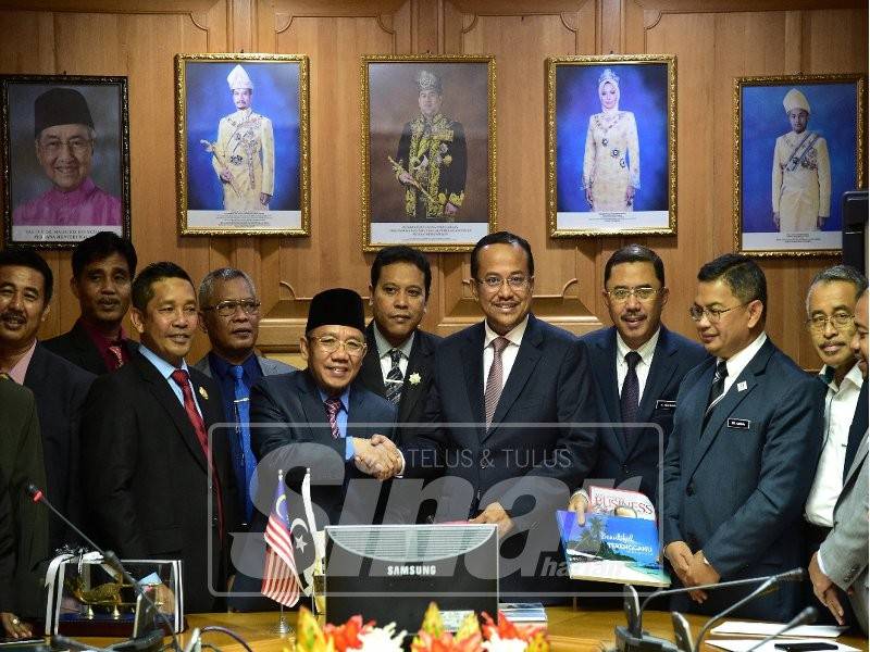 Ahmad Samsuri (empat, kanan) berjabat tangan bersama Bupati Lombok Utara, Dr Najmul Akhyar selepas pertemuan bersama yang diadakan di Pejabat Menteri Besar, di sini, hari ini.
