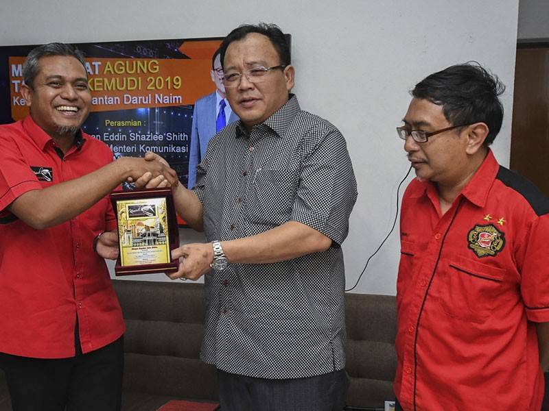 Timbalan Menteri Komunikasi dan Multimedia, Eddin Shazlee Shith (tengah) menerima cenderahati daripada Presiden Kelab Media Kelantan Darulnaim (KEMUDI), Azran Fitri Abdul Rahim (kiri) selepas merasmikan Mesyuarat Agung Tahunan KEMUDI 2019 di Press House, Taman Sari, hari ini. - Foto Bernama