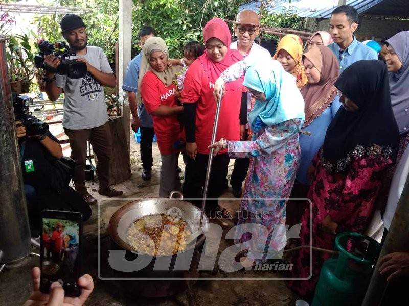 Wan Azizah membantu menggoreng ayam ketika tiba sempena majlis tersebut, hari ini.