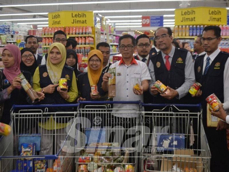 Chee Leong menunjukkan pelbagai produk makanan yang dirampas kerana menyalahi Akta Makanan 1983 di sebuah pasar raya di Cheng di sini, hari ini.