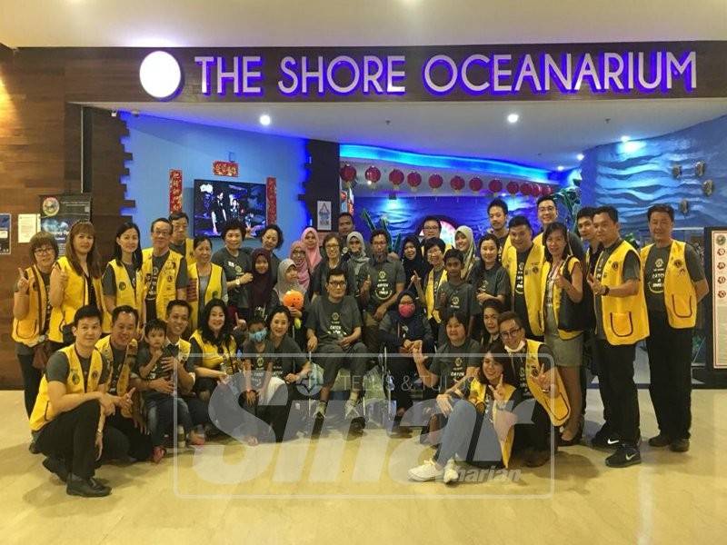 Hong Jin (tengah) bersama ahli bergambar dengan kanak-kanak penghidap kanser selepas program lawatan ke The Shore Oceanarium.
