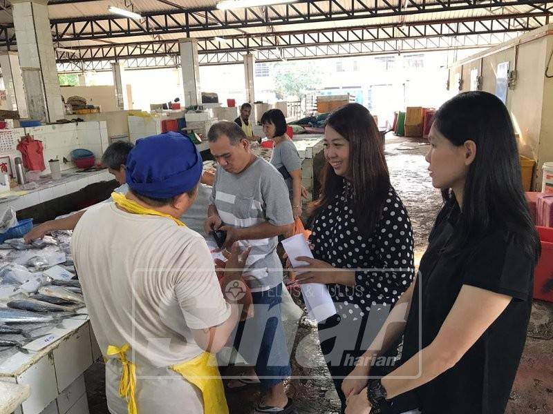 Cai Tung (dua,kanan) ketika bertemu peniaga di pasar berkenaan, hari ini.