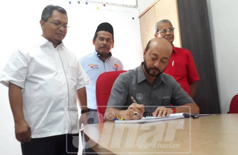 Mukhriz menandatangani buku pelawat selepas merasmikan Pusat Khidmat Rakyat Dun Sungai Limau, dekat sini. Turut kelihatan Zahran (kiri) dan Ku Abd Rahman (kanan).