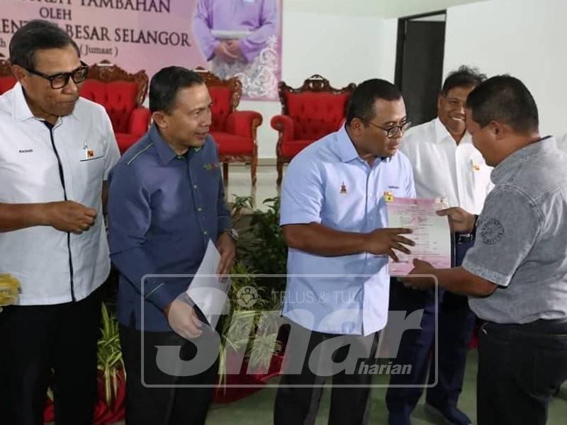 Abdul Rashid (kiri) mengiringi Aminudin menyerahkan geran kepada penerima.