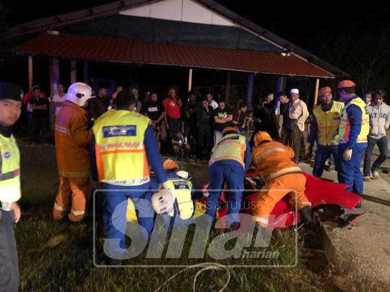 Anggota bomba berusaha mengeluarkan mangsa yang dipercayai tersepit dalam kenderaan di tempat kejadian.