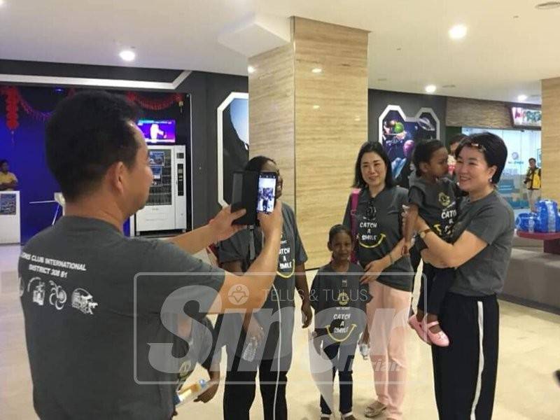 Hong Jin (tengah) bersama ahlinya bergambar dengan kanak-kanak penghidap kanser selepas program lawatan ke The Shore Oceanarium.