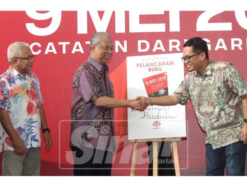 Nik Nazmi (kanan) bersalam dengan Muhyiddin ketika simbolik pelancaran Buku 9 Mei 2018 Catatan Dari Garis Depan sambil diperhatikan Hussamuddin.