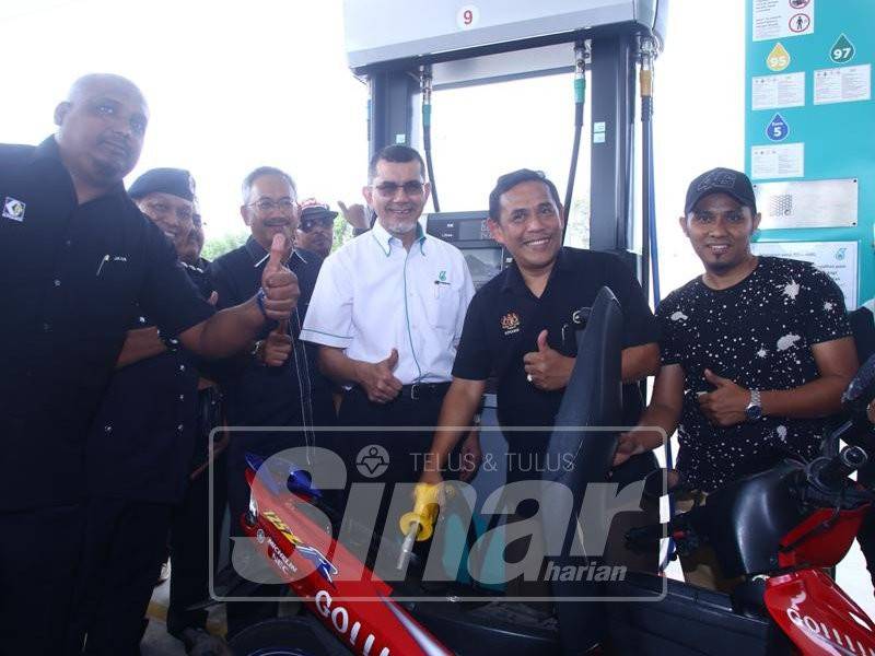 Muez membantu pengguna mengisi minyak petrol dan diperhatikan Syed Zainal (empat,kanan) ketika majlis Keselamatan Petroleum Peringkat negeri Melaka di Stesen Minyak Petronas, Jalan Tun Kudu, Bukit Katil, di sini, tadi.