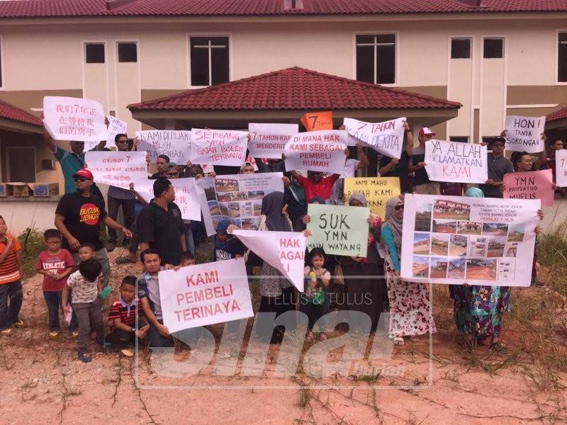 Sebahagian daripada pembeli menunjukkan sepanduk ketika membuat demostrasi di tapak projek perumahan tersebut, hari ini.