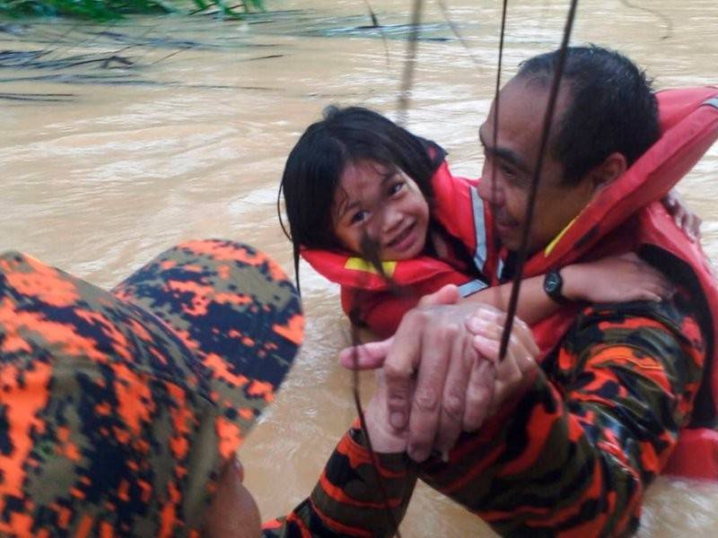 Dua anggota bomba memindahkan seorang kanak-kanak ke tempat selamat di Taritipan, hari ini. Hujan berterusan sejak petang semalam sehingga petang ini menyebabkan mangsa meningkat kepada 1,425 orang daripada 510 keluarga, dan kesemua mereka dipindahkan ke pusat pemindahan sementara (PPS). - Foto Bernama