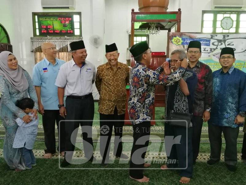 Norsham (kiri) bersama mengiringi Mohammad Yaacob (empat, kiri) yang hadir bersama Huzairi dan pemimpin setempat sempena sesi penyampaian bantuan di Masjid Jamiul Muhammadiah Kampung Kuantan, pagi tadi.