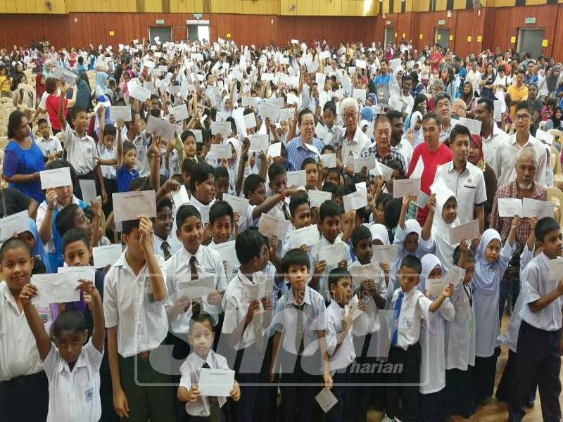 Guan Eng bergambar menyampaikan bantuan untuk pelajar miskin bagi kawasan Parlimen Bagan di sini pagi tadi.