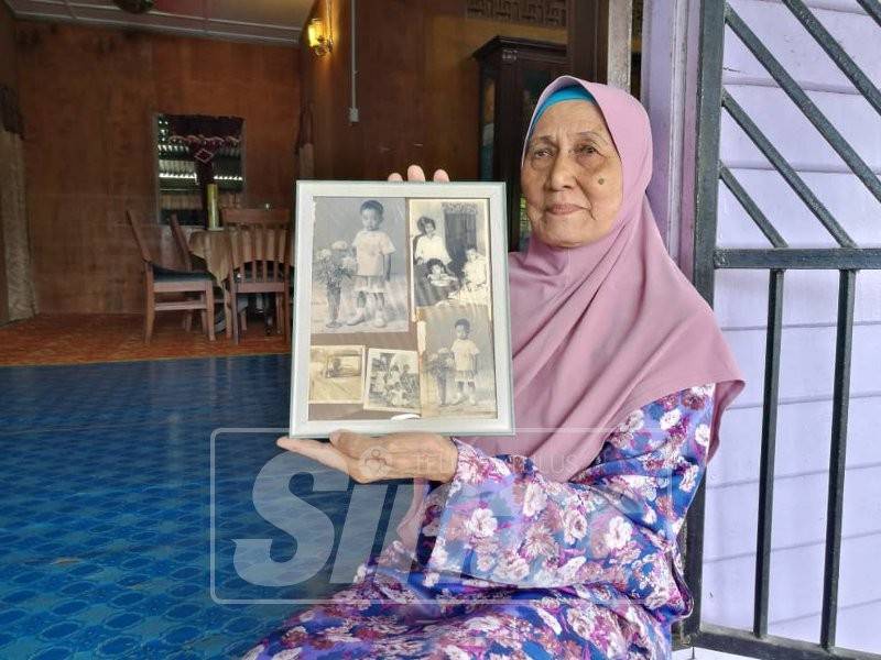 Hasimah sedang memegang gambar Al-Sultan Abdullah ketika kecil ketika ditemui di rumahnya di Kampung Mengkasar, hari ini.