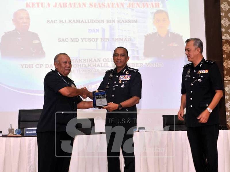 Mohd Khalil (tengah) menyampaikan cenderahati kepada Kamaluddin (kiri) sambil diperhatikan Md Yusof (kanan).