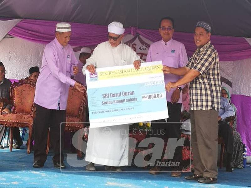 Abdul Hadi (tengah) menerima sumbangan pelbagai pihak bagi membangunkan Sekolah Rendah Darul Quran di Bukit Chempedak, hari ini.